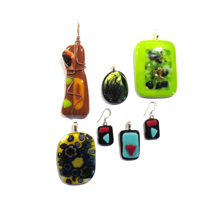 KPM_WS_FG_Jewelry_720x720px A collection of seven colorful handmade glass and resin pendants and earrings with varied designs.